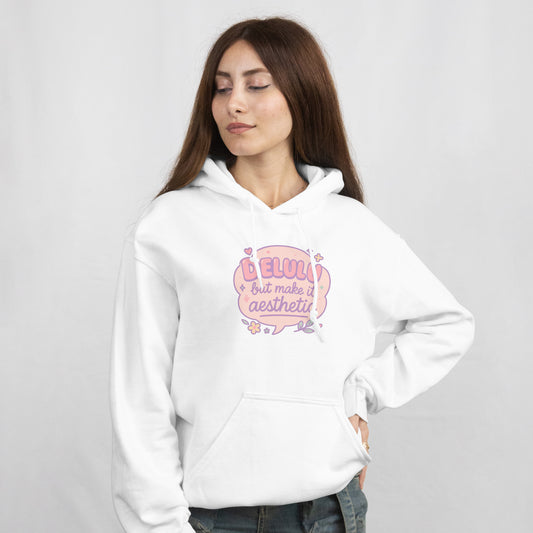 Woman wearing RubiBloom white hoodie with pastel quote “Delulu but make it aesthetic” — cute soft girl aesthetic sweatshirt with embroidered sleeve text “Daydream Believer Club”, cozy outfit for dreamers.