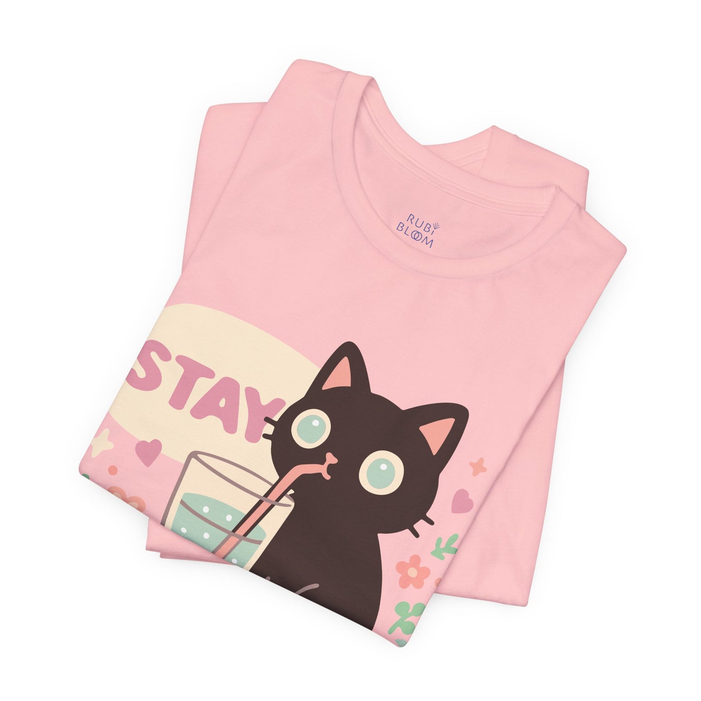 Folded pink pastel t-shirt with cute black cat design — Ruby Bloom cozy cotton tee for artists and creative dreamers, perfect aesthetic gift.