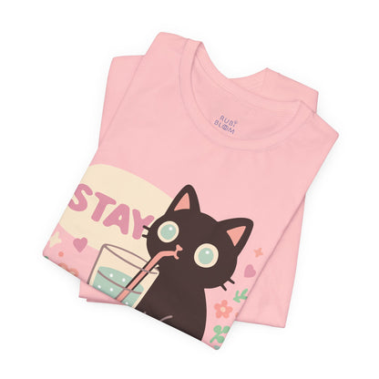 Folded pink pastel t-shirt with cute black cat design — Ruby Bloom cozy cotton tee for artists and creative dreamers, perfect aesthetic gift.