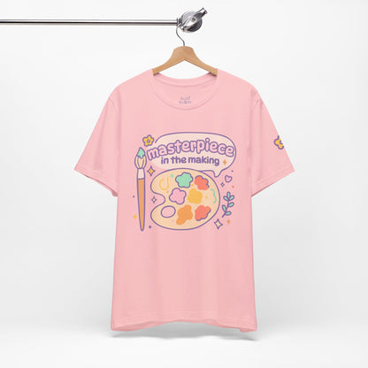 Pink “Masterpiece in the Making” RubiBloom shirt — soft pastel art t-shirt with painter’s brush and color palette, perfect for cozy days and creative outfits.