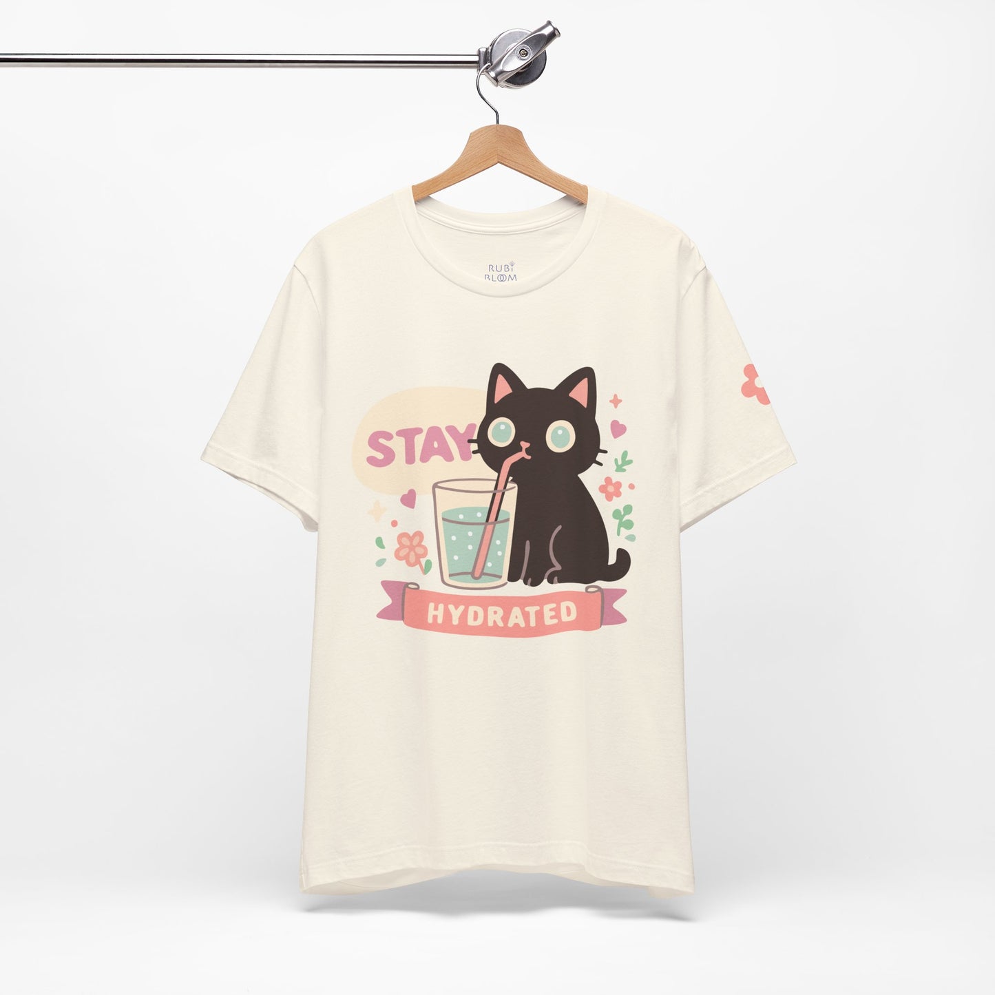 Cream “Stay Hydrated” pastel shirt — kawaii black cat with flowers and glass of water, dreamy aesthetic tee for self-care mornings.
