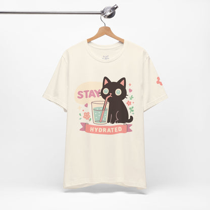 Cream “Stay Hydrated” pastel shirt — kawaii black cat with flowers and glass of water, dreamy aesthetic tee for self-care mornings.
