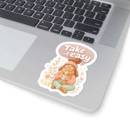Take It Easy vinyl sticker 4x4 inches on laptop, cozy autumn aesthetic featuring girl with tea and puppy.