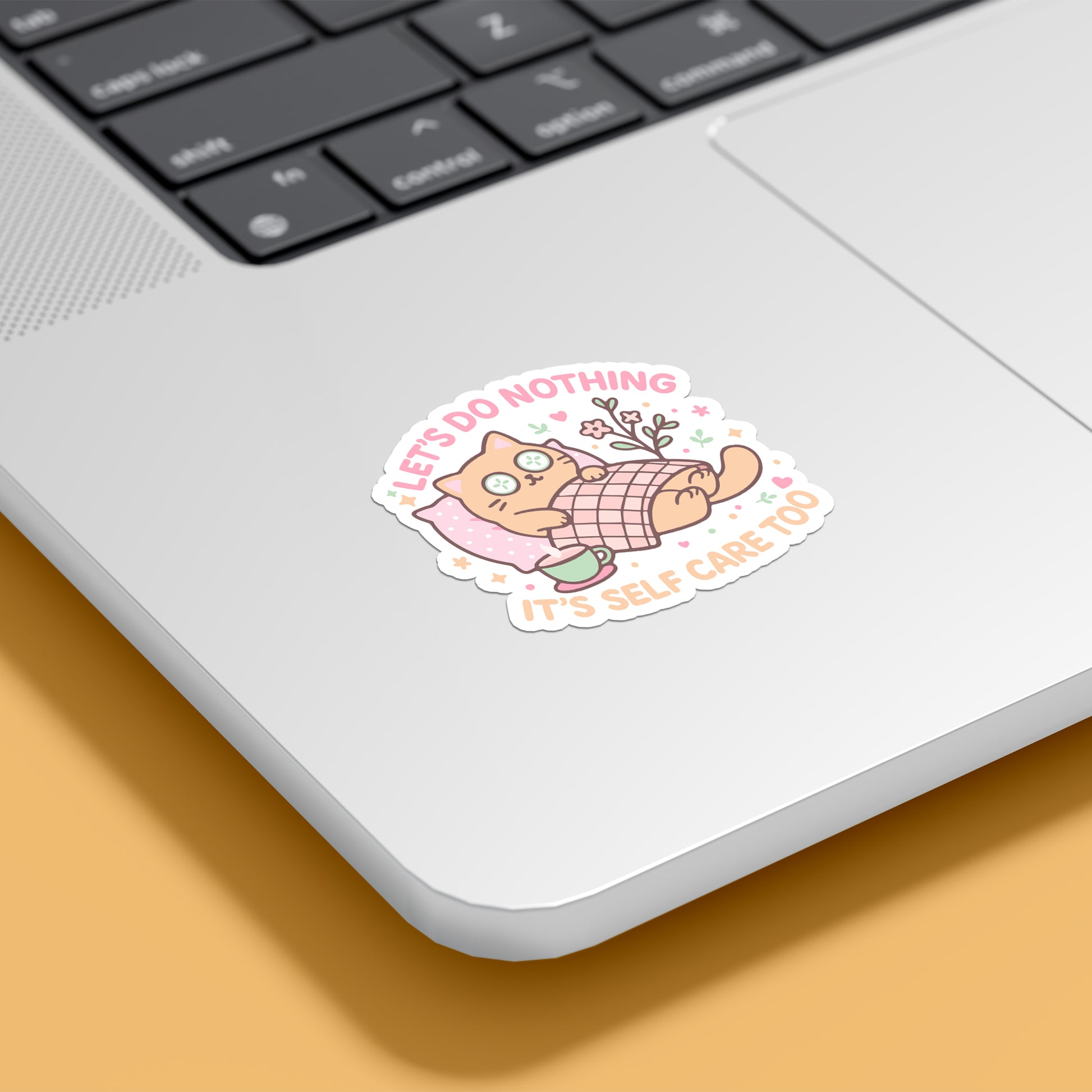 Cute “Let’s Do Nothing, It’s Self Care Too” sticker on laptop — cozy pastel cat resting under blanket, RubiBloom vinyl sticker for journaling, aesthetic gifts, and slow days.